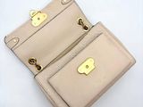 beige leather purse with gold hardware on top of it