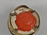 an old coin with a red seal on it