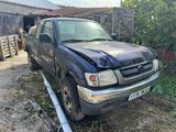 a truck that has been damaged and is parked in front of a barn