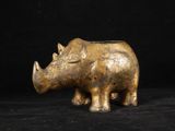 un gros plan d'une statue de rhinocéros en bronze sur fond noir