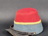 un bonnet rouge et bleu orné d'un ruban jaune