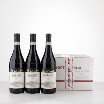 three bottles of red wine sit in front of a box