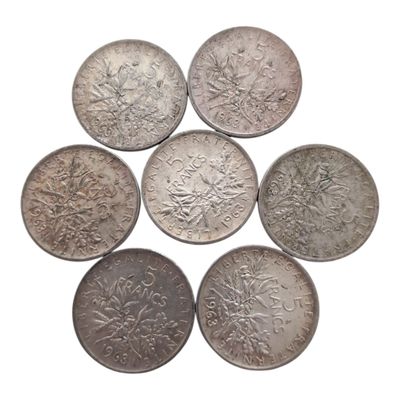six pièces d'argent sont disposées en cercle sur un fond blanc