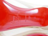 pair of red high heeled shoes sitting on top of a white surface
