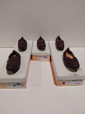 Quatre paires de chaussures sont exposées dans une vitrine