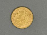 a close up of a gold coin on a gray surface