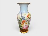 un vase avec des fleurs peintes dessus, posé sur une table