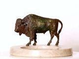 une statue en bronze représentant un bison, posée sur un socle en marbre