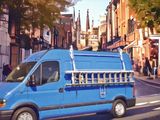 a blue van that is driving down the street