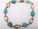 a gold and turquoise bracelet with turquoise stones