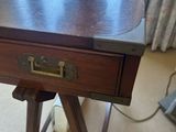 a small wooden table with a lamp on top of it