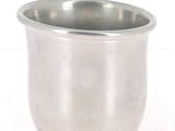 une tasse en argent posée sur une surface blanche
