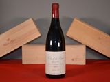 a bottle of wine sitting on a table next to two wooden boxes