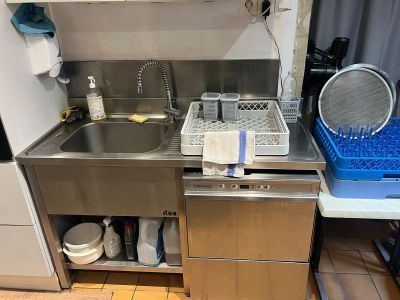 une cuisine équipée d'un évier, d'un lave-vaisselle et d'un égouttoir à vaisselle