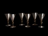 quatre verres à vin sont alignés sur un fond noir