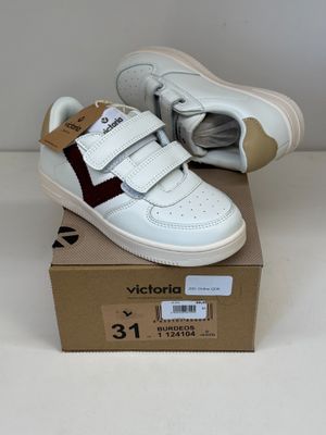une boîte sur laquelle est posée une paire de chaussures blanches