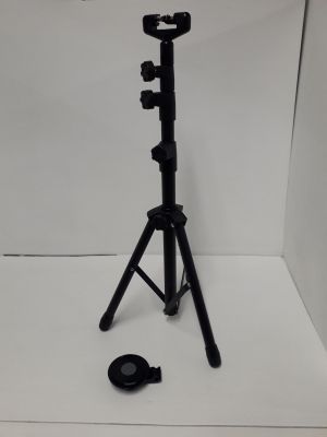 un petit trépied sur lequel est posée un appareil photo, le tout dans une boîte blanche