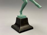 une image représentant une statue en bronze d'une femme tenant une raquette de tennis