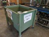 a green bin with a sign on it in a warehouse