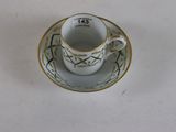 a small cup and saucer sitting on a white table