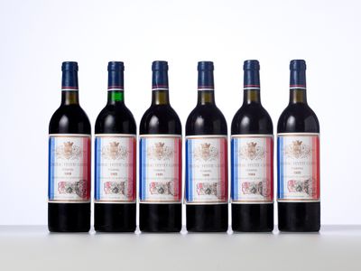 six bottles of red wine lined up in a row on a table
