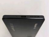 the back of a black cell phone sitting on top of a white table