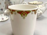 three cups and a teapot sitting on a table