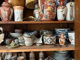 de nombreux types de poteries sur les étagères de cette vitrine