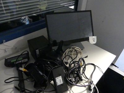 un bureau sur lequel se trouvent un ordinateur et de nombreux câbles