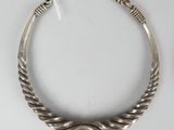 a close up of a silver necklace on a white surface