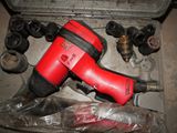 a red cordless drill and other tools in a case