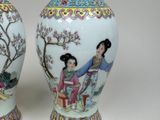 pair of asian vases with a woman and a child on them
