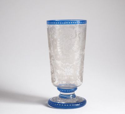a glass with a blue rim sitting on a white surface