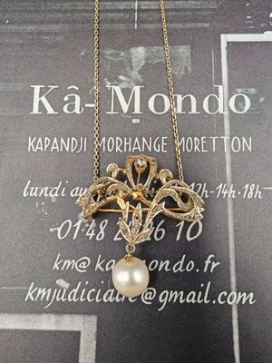 une photo d'un collier auquel est suspendue une perle