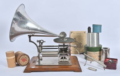 un gramophone argenté posé sur un socle en bois