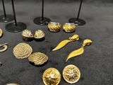 a lot of gold jewelry on display on a black table