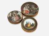 trois assiettes miniatures ornées de peintures représentant des personnes, posées sur une table