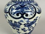a blue and white vase with a face on it