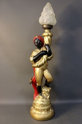 Porte torchère figurant un nubien en stuc polychrome.