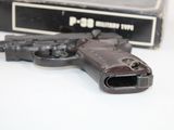 a gun that is sitting on a table next to a box