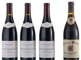 four bottles of red wine are lined up on a white surface