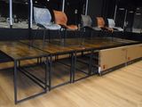 several chairs and tables in a room with black walls and wood flooring