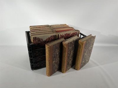 plusieurs vieux livres sont empilés sur une surface blanche