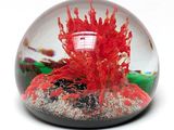 une boule de verre contenant une flamme, posée sur une surface blanche