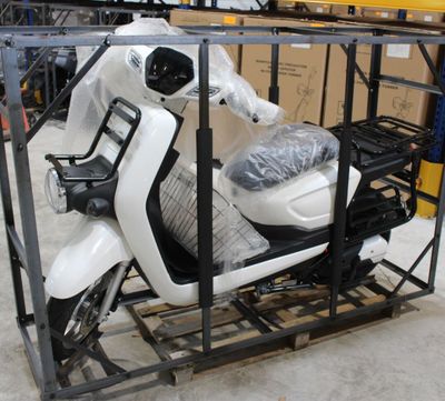 un scooter posé sur un chariot dans un entrepôt