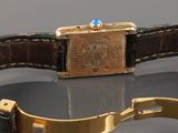 an image of a gold watch with a brown leather strap