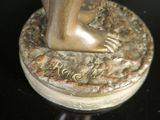 a bronze statue of a foot on a base
