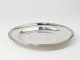 une image représentant une assiette en argent posée sur une surface blanche