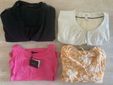 three tops and a bag are sitting on the floor next to each other