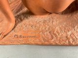a statue of a nude woman sitting on a table